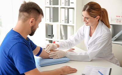 Amostra de sangue sendo coletada em um ambiente cl&iacute;nico