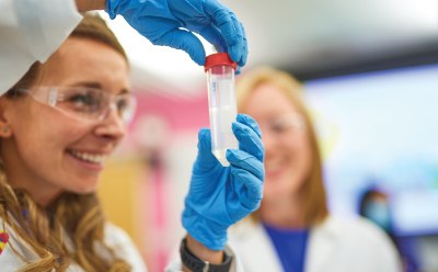 Scientists smiling while studying a test tube in a laboratory