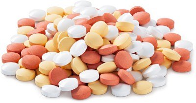 A pile of multicolored tablets, including white, yellow, and red pills, isolated on a white background.