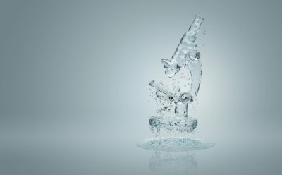 A transparent glass microscope with water droplets suspended in mid-air, set against a light gray background A transparent glass microscope with water droplets suspended in mid-air, set against a light gray background