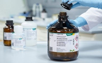 A laboratory setting where a researcher is handling a bottle of LiChrosolv® Acetonitrile