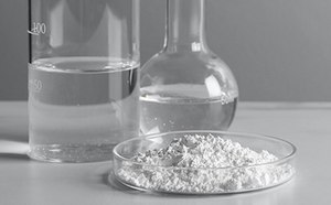 Laboratory glassware and a petri dish containing a white substance.