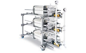 Filtration equipment with multiple cylindrical filters connected by metal piping, set against a white background.