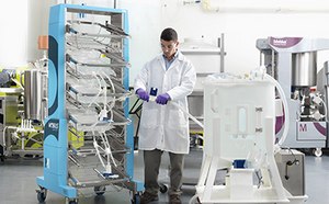 Lab technician connecting a 2D bag assembly on a Mobius® container cart to a Mobius® mixer