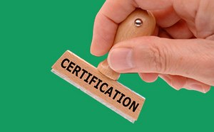 The image depicts a hand poised to stamp with a wooden rubber stamp labeled “CERTIFICATION” against a vibrant green backdrop.