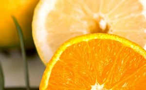 A vibrant close-up of a juicy, sliced orange with a contrasting slice of lemon in the background, highlighting the fresh and appetizing texture of the citrus fruits.