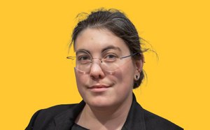 Taylor Szasz-Green headshot with a vibrant yellow background