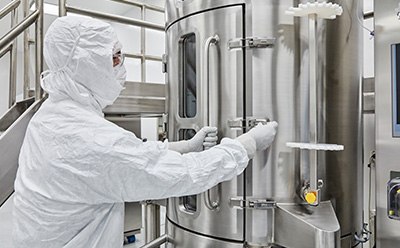 AAV Platform Manufacturing operator in PPE operates a 1,000L single-use bioreactor during AAV production