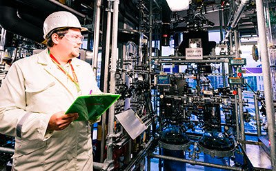 Manufacturing and custom packaging capabilities in over 45 manufacturing sites worldwide Manufacturing worker in a production area with pipes