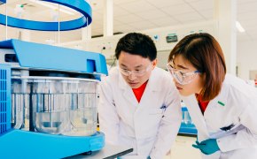 Scientists in production facility performing quality control and testing on production materials and bulk chemicals Scientists in production facility performing quality control and testing on production materials and bulk chemicals