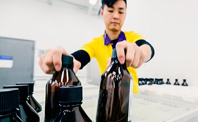 Global manufacturing capabilities to deliver a comprehensive portfolio Worker packing glass bottles into a box