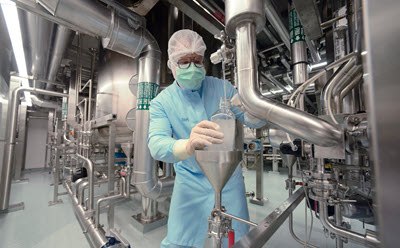 Manufacturing and custom packaging capabilities in over 45 manufacturing sites worldwide Manufacturing worker in a production area with pipes