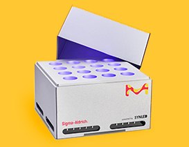 A closed box of laboratory photoreactors, featuring a purple and white design, placed on a yellow background.