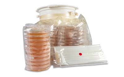 A collection of sealed bags containing various petri dishes and a flat tray, all arranged together, highlighting the sterile packaging and preparation for laboratory use. A collection of sealed bags containing various petri dishes and a flat tray, all arranged together, highlighting the sterile packaging and preparation for laboratory use.