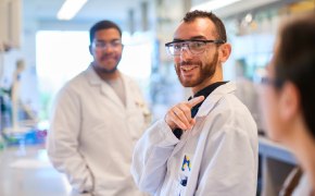 Professionals smiling in lab coats in a lab setting